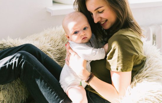 woman-in-green-shirt-holding-baby-while-sitting-698877